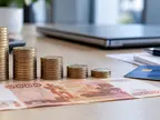 Стопки монет убывающей высоты и купюра 5000 рублей